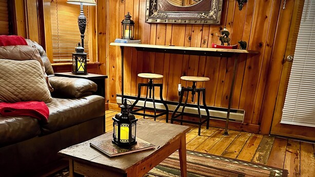 Une pièce chaleureuse avec un canapé en cuir, une table basse en bois et un tapis à motifs.