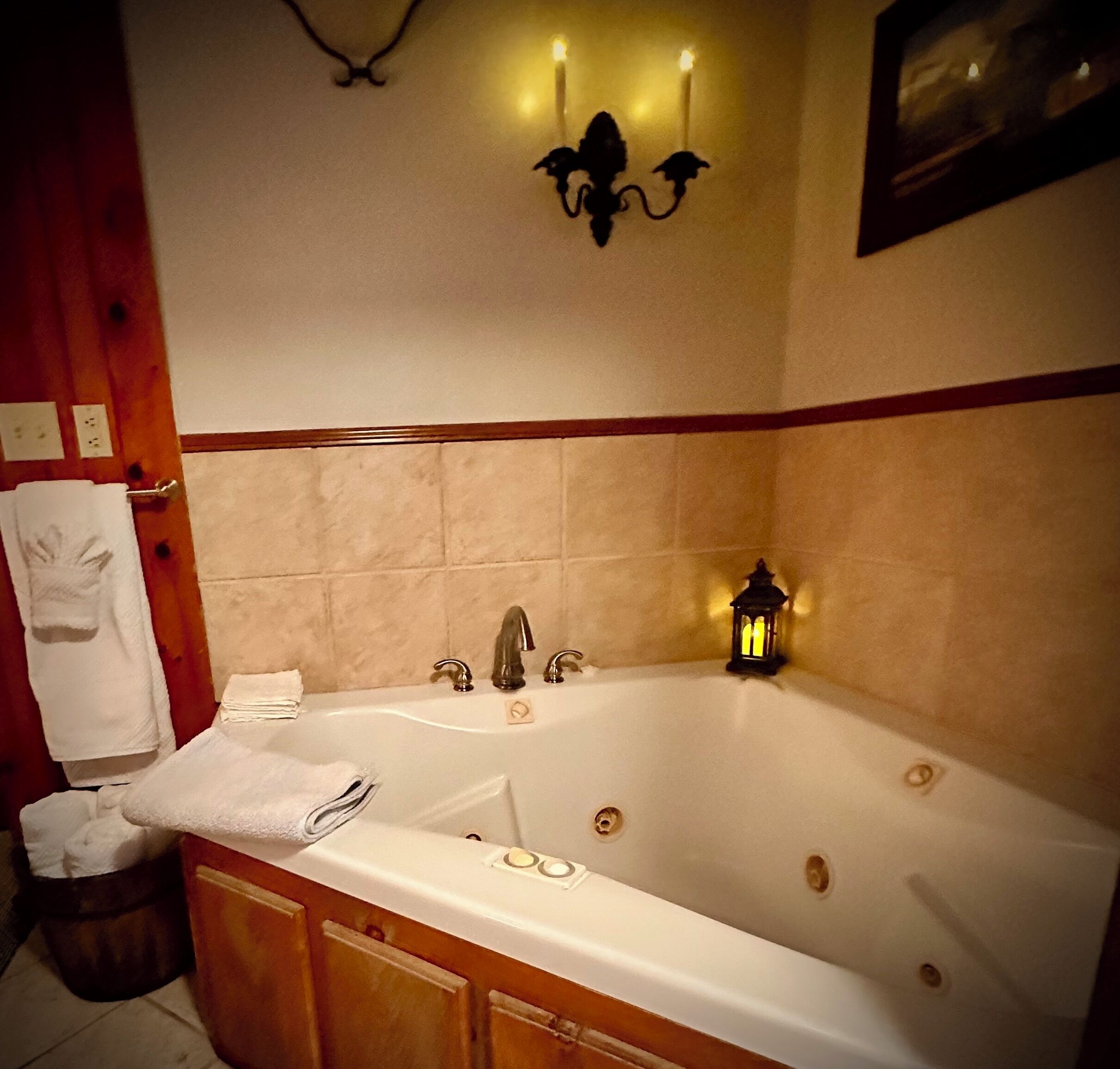A bathroom with a bathtub, a sink, and a toilet. There are towels hanging on the wall and a trash can.