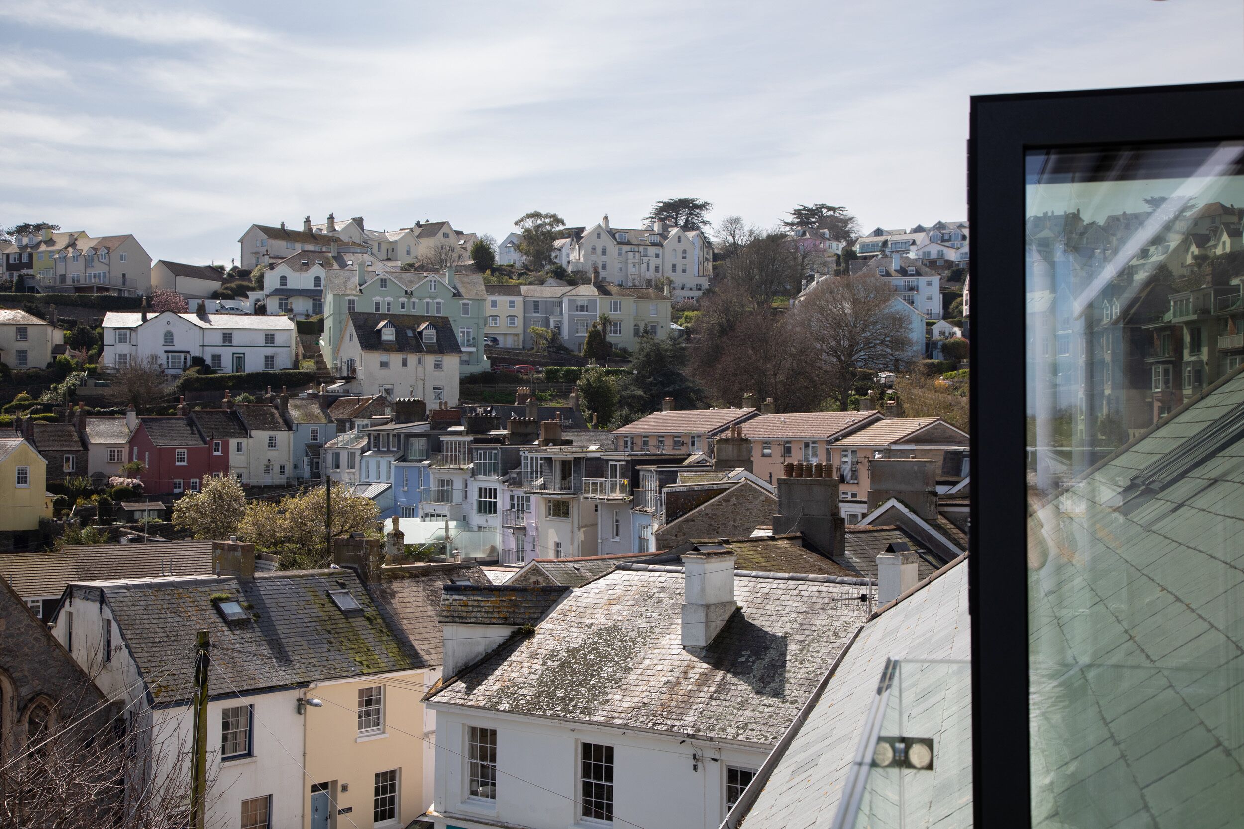 Une ville côtière où se côtoient des immeubles résidentiels, dont certains présentent des cheminées et des fenêtres bien visibles.