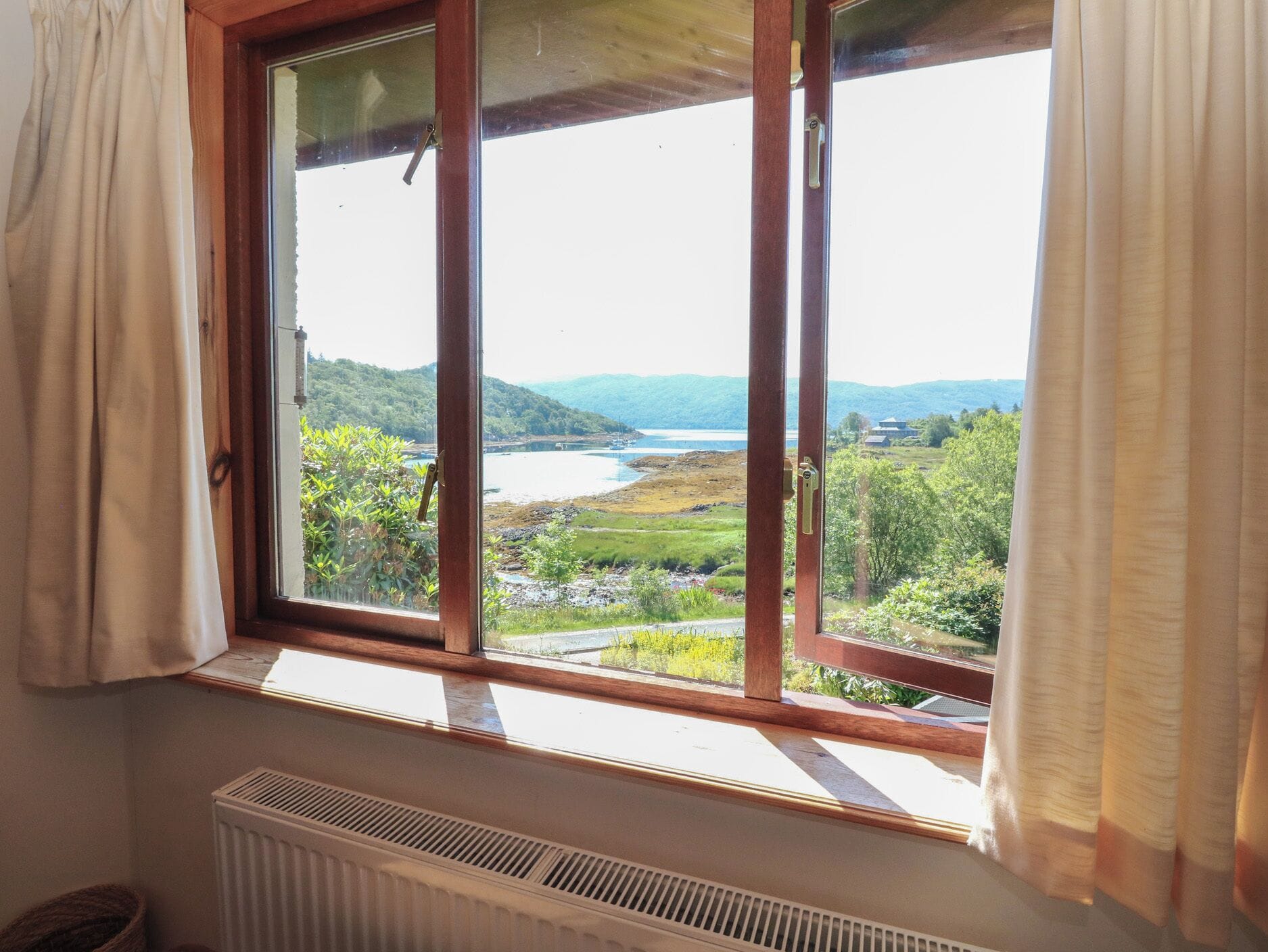 A room with a large window overlooking a scenic landscape.