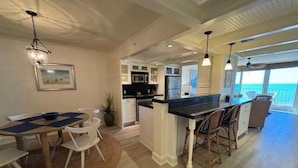 A spacious kitchen with a central island, white cabinetry, and a view to the outside. - Delightful Gulf views from the 11th floor!-WS1102 (Naples)