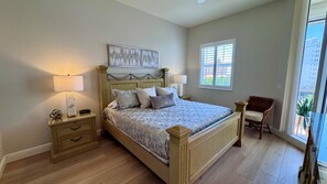 A bedroom with a bed, nightstands, a chair, a window, and a painting on the wall. - Beautiful 3-bedroom condo walking distance to the beach - Reg 4-PH4 (Naples)