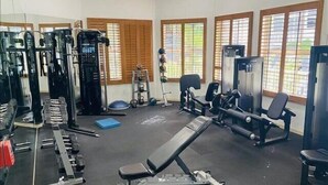 A gym with various exercise equipment, including weight machines, free weights, and cardio machines. - Great location! 2 blocks from the beach with beautiful pool views -Reg 5-404 (Naples)