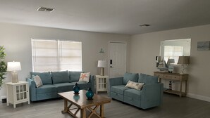 A living room with two sofas, a coffee table, and a side table with a lamp. - COUNTRYSIDE VACATION BY THE LAKE HOUSE CENTRAL FLORIDA (Frostproof)