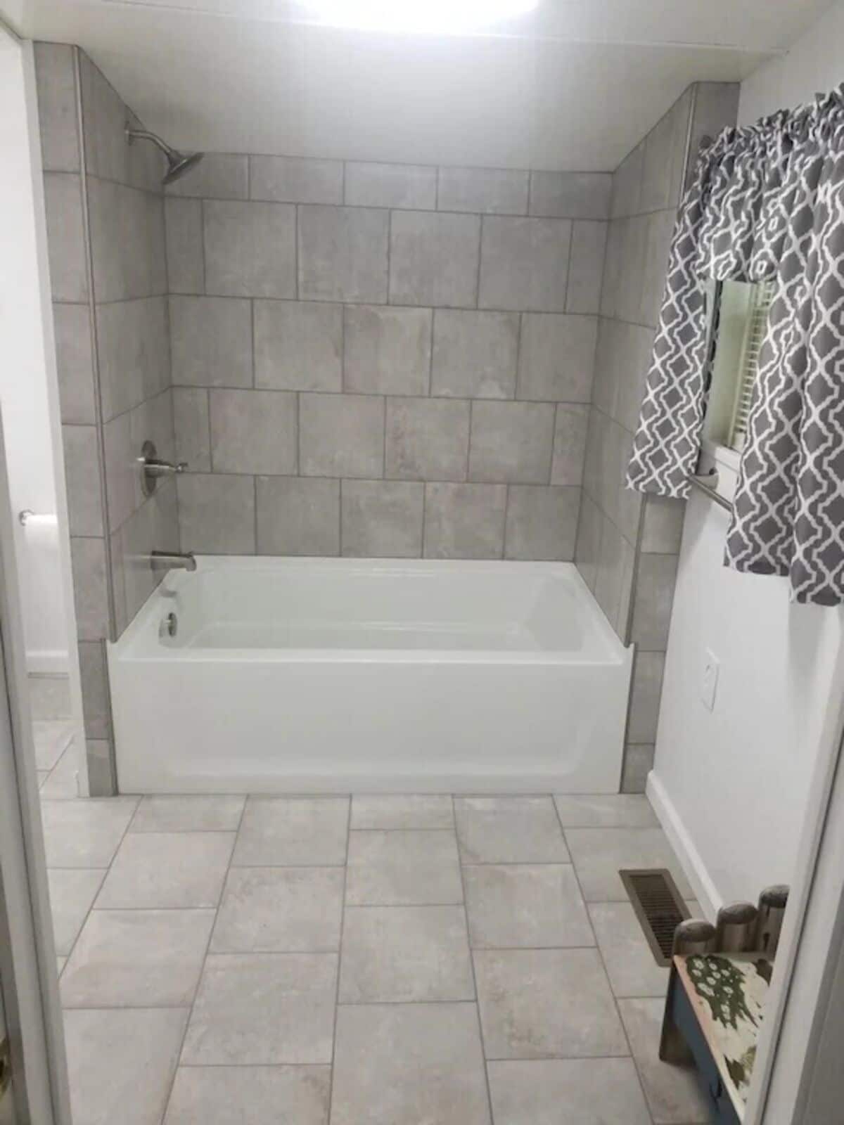 Ein Badezimmer mit Badewanne, gefliesten Wänden und einer Duschkabine.
