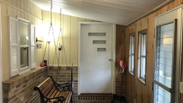 A covered porch with a swing, a bench, and a door leading inside. - Horseshoe Cottage:  SKI, FISH, HIKE & BIKE: Paradise near all things outdoor! (Parsons)