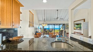 Uma cozinha moderna com bancadas de granito, armários de madeira e uma ilha grande.