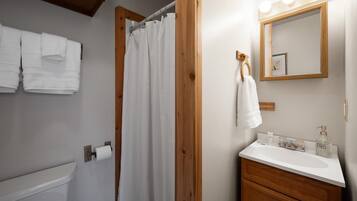 Chuveiro, toalhas de banho, sabonete, shampoo