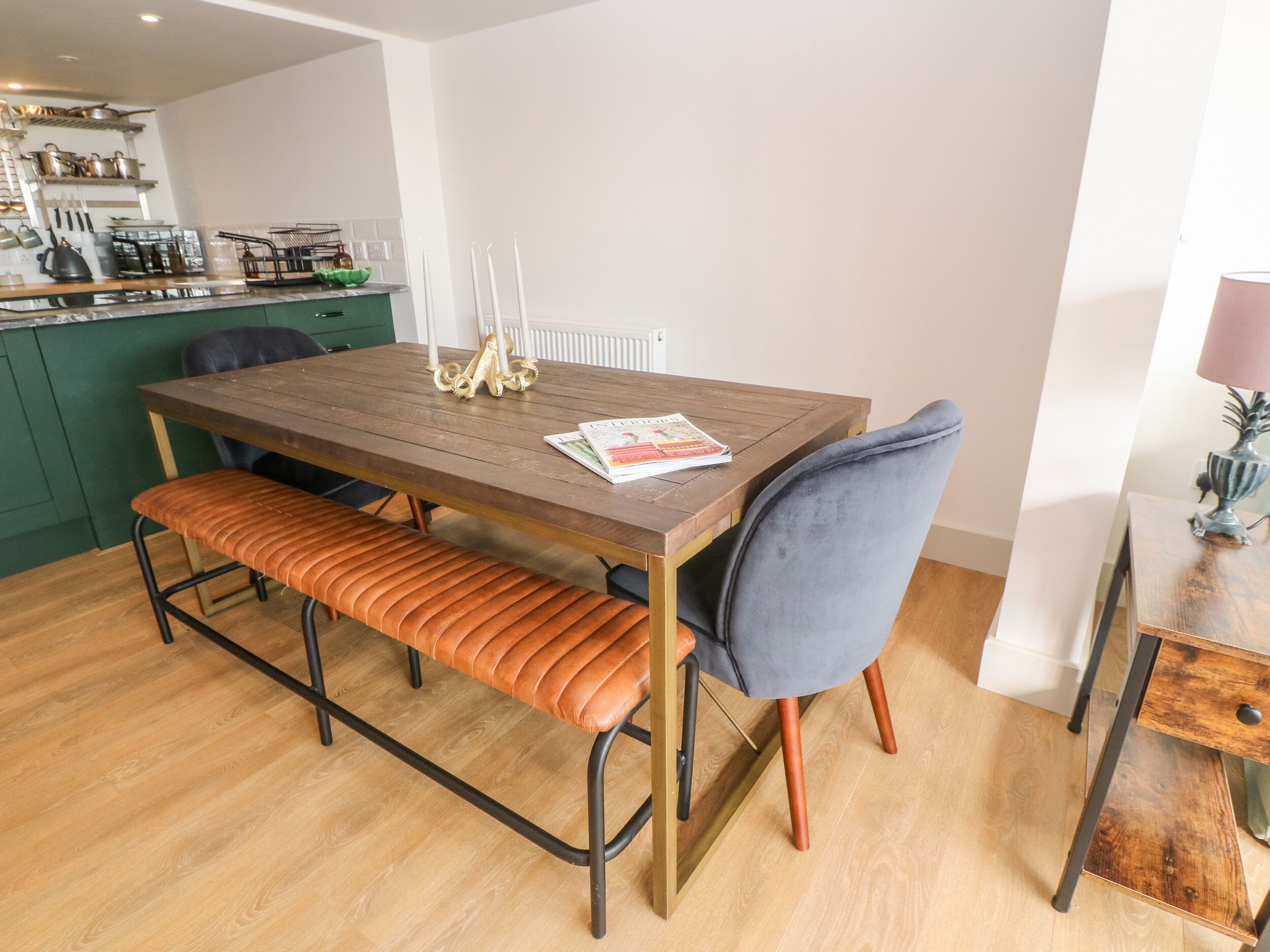 A dining area with a wooden table, bench, and chairs.