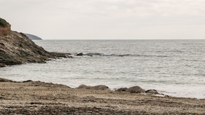 A coastal landscape with rocky terrain and calm sea. - 16 Arwenack Street (Falmouth)