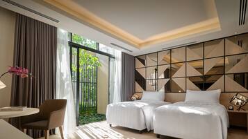A hotel room with two beds, a desk, a chair, and a large window with curtains.