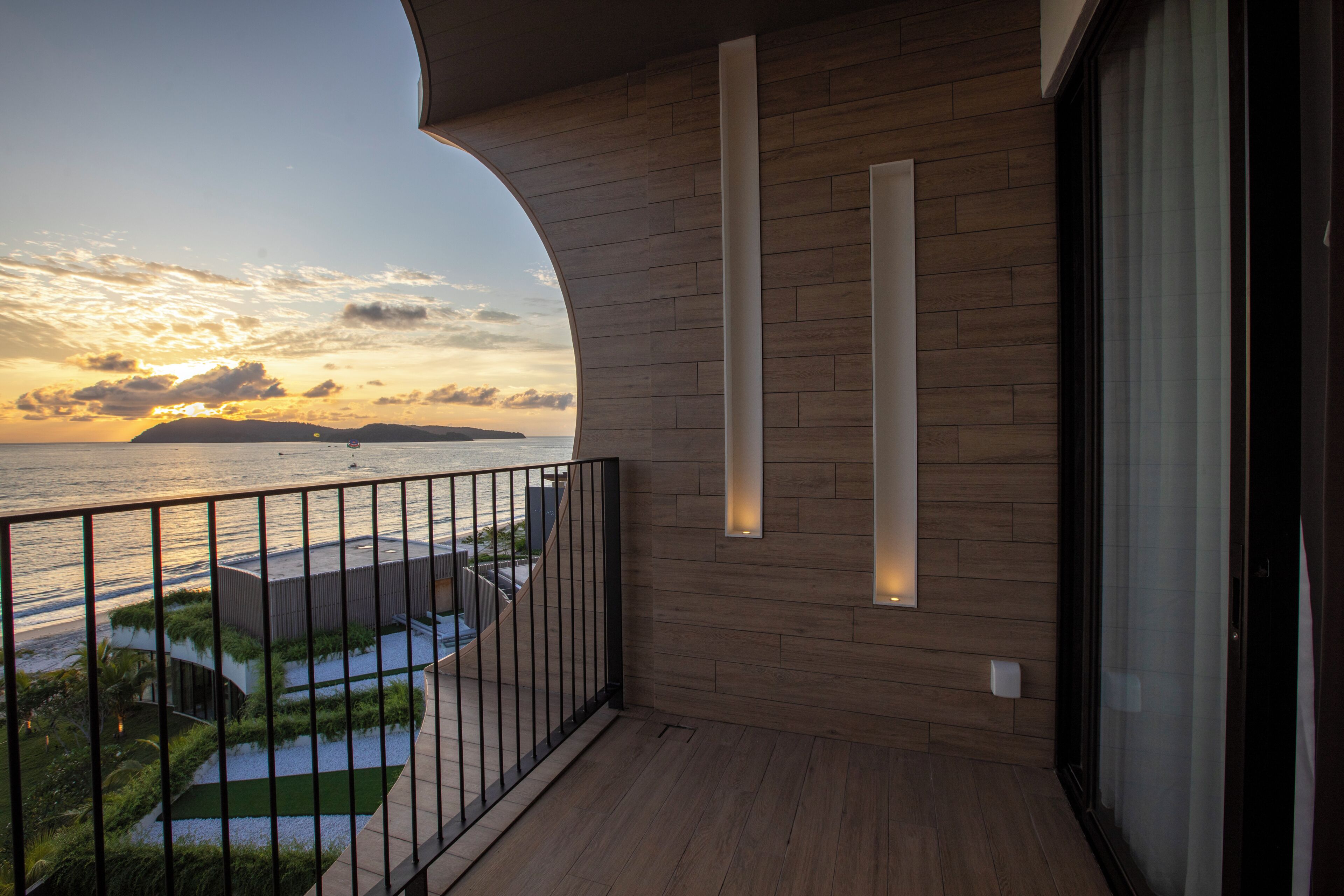 A balcony with a view of the sea and sunset.