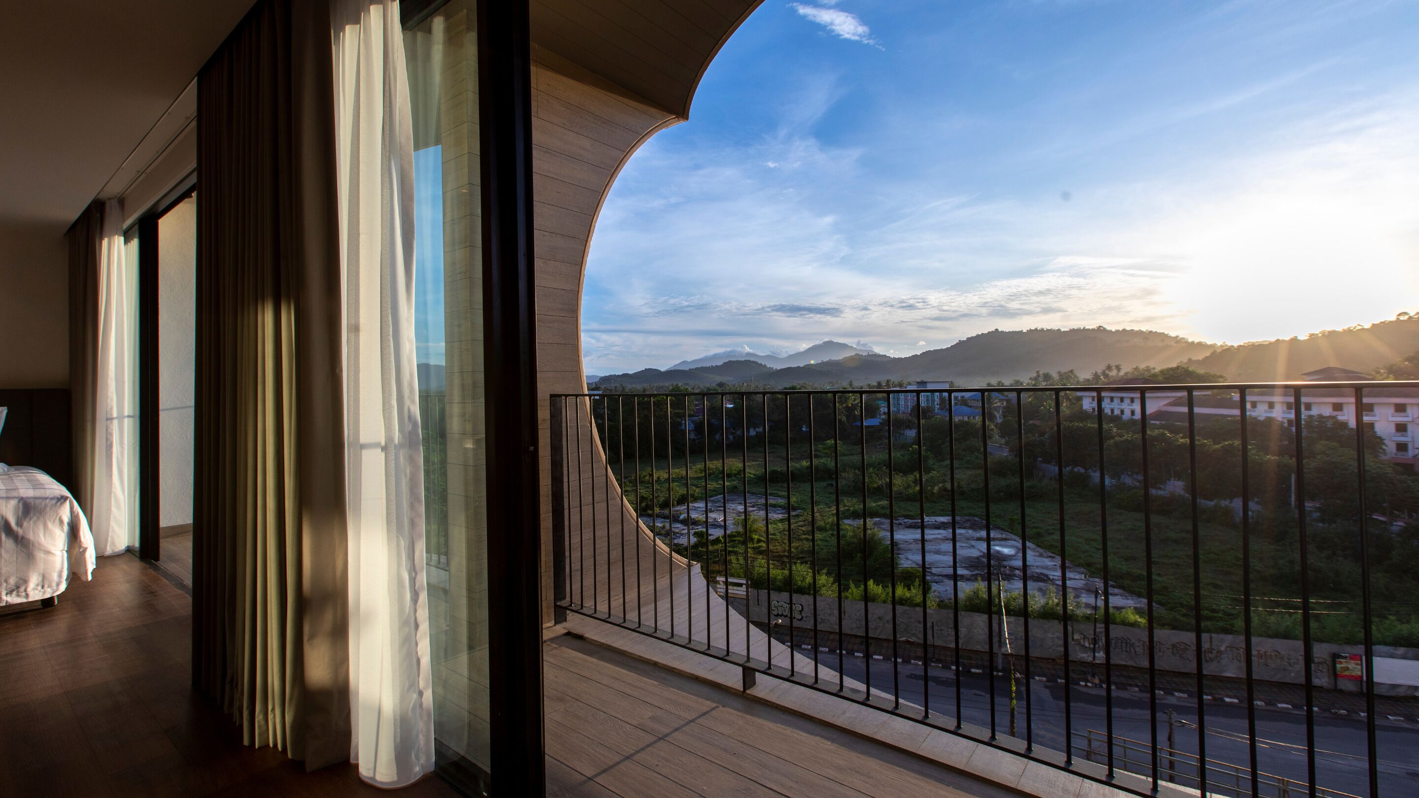 A balcony with a view of a mountainous landscape and a road.