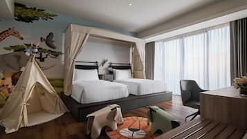 A hotel room with a large bed, a desk, a chair, a tent, and a rug.