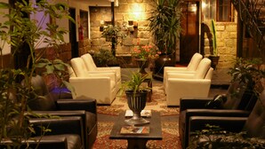 A cozy lounge area with leather sofas, a central coffee table, and potted plants. - Hotel Montecristo Cusco (Cusco)