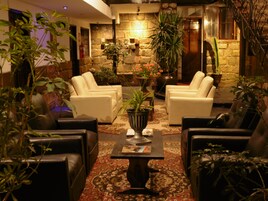 A cozy lounge area with leather sofas, a central coffee table, and potted plants.