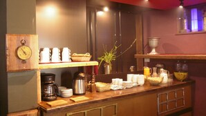 A breakfast bar with coffee makers, cups, and a clock. - Hotel Montecristo Cusco (Cusco)