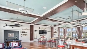 A spacious hotel lobby with a pool table, bar area, and dining space.