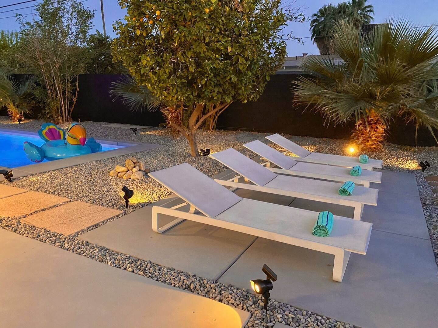 A poolside area with lounge chairs and a small inflatable pool.