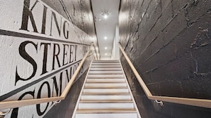Una scala con corrimano che porta a un pianerottolo con un cartello che indica 'KING STREET COMMON'.