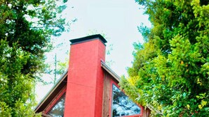 Een rood gebouw met een ster op de muur, een trap en een groot raam.