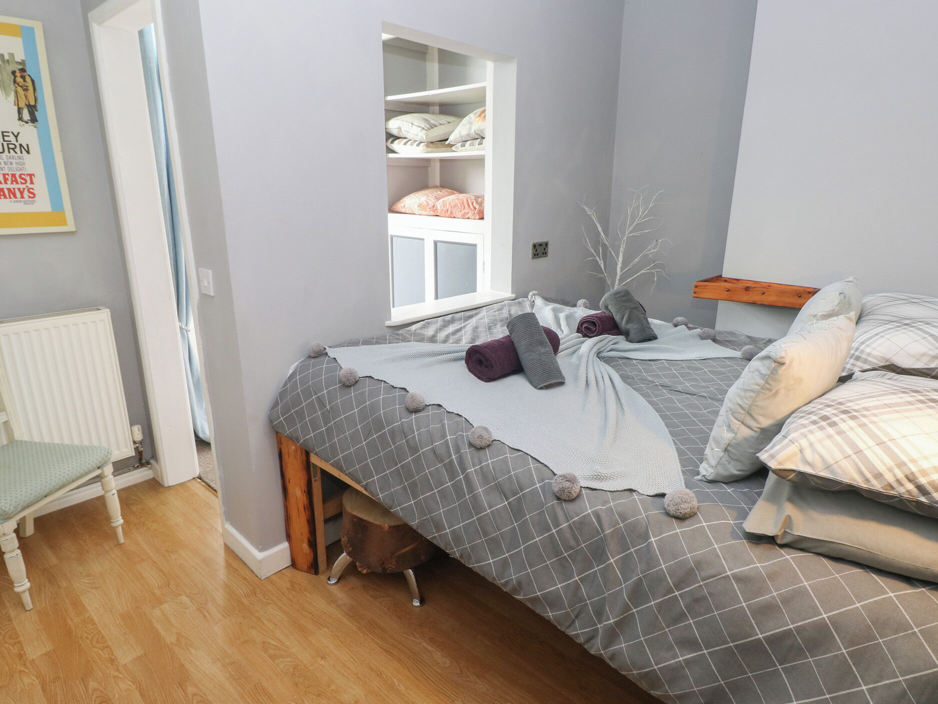 Une chambre à coucher avec un lit, une fenêtre, un radiateur et une chaise.