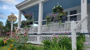A porch with hanging flower baskets and a sign for 'Lindsay's Kitchen'. - The Cornish Inn (Cornish)