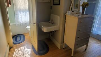 A bathroom with a sink, mirror, and a dresser.