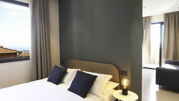 A hotel room with a bed, a bedside lamp, and a view of the cityscape.