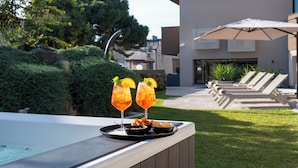 A poolside area with a hot tub, lounge chairs, and umbrellas. - Ollen apartments (Catania)