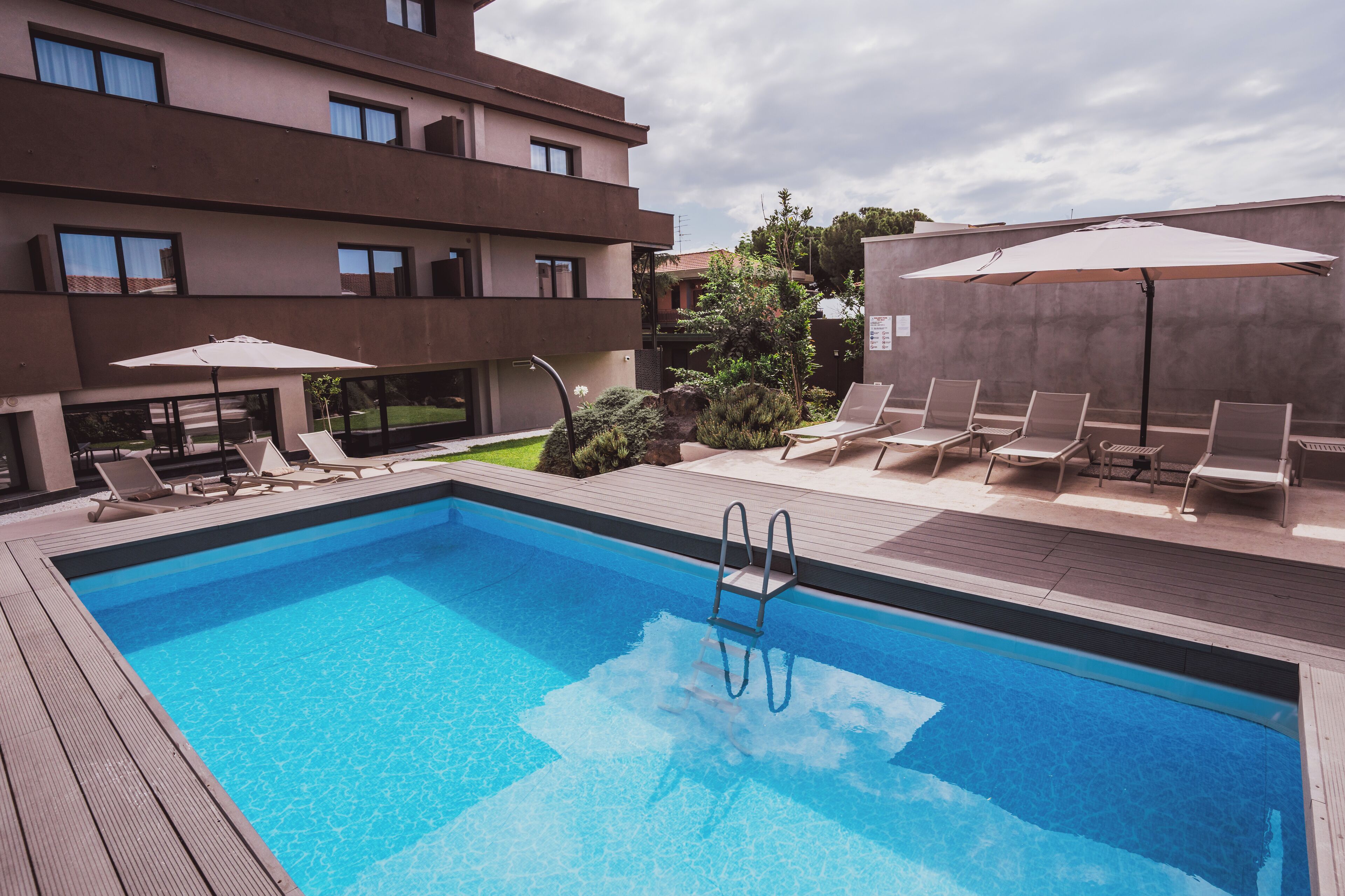 季节性开放的室外游泳池，池畔遮阳伞，日光浴躺椅