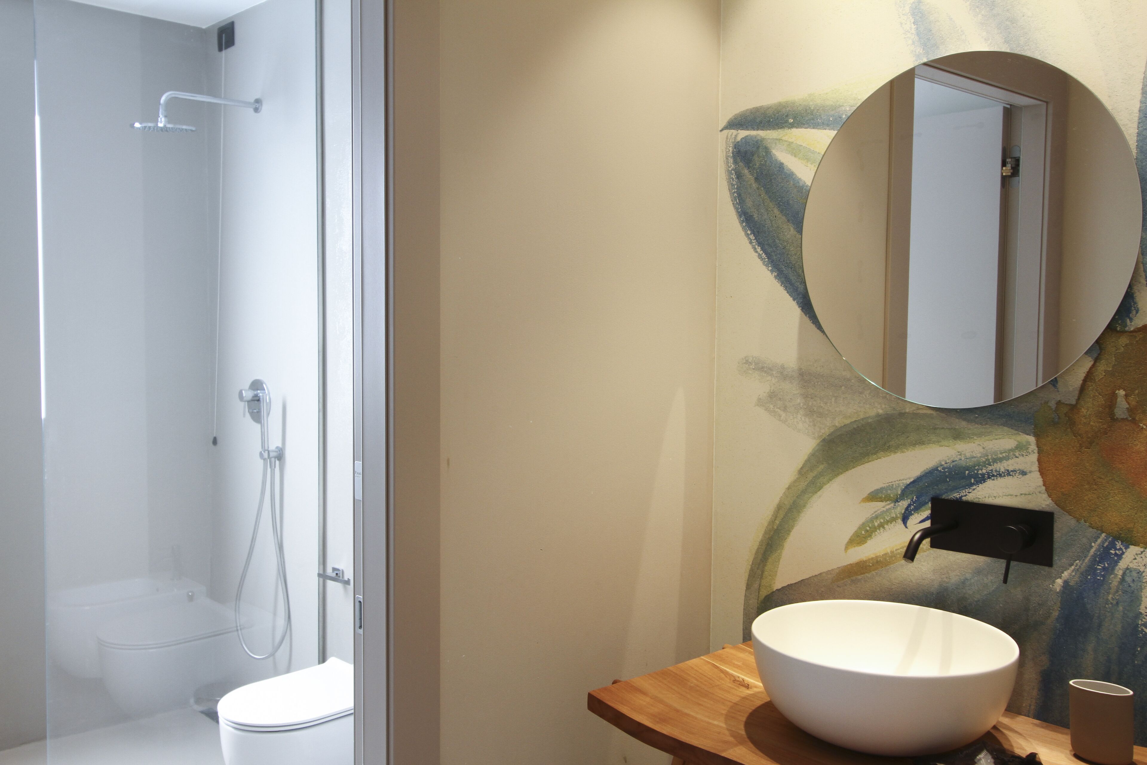 Un baño con ducha, inodoro y lavamanos con espejo.