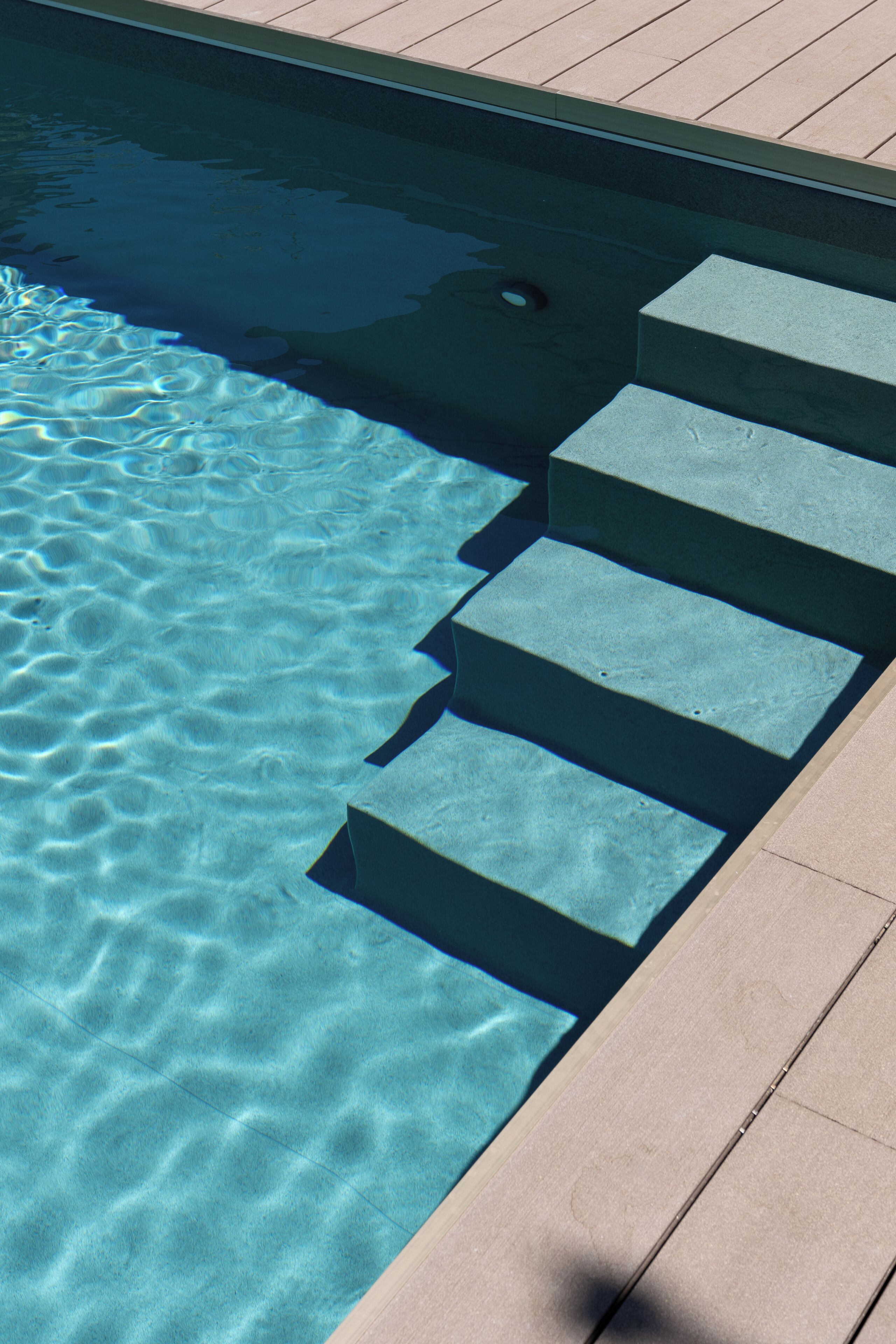 A clear swimming pool with steps leading into it.