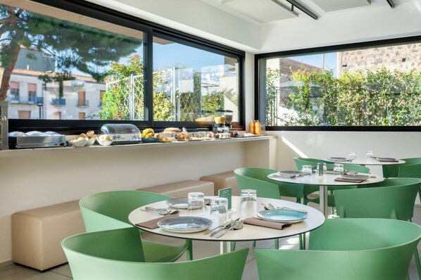 Enjoy meals with a view at this stylish dining area, featuring round tables and comfortable seating.