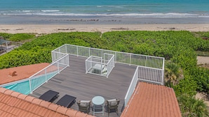 A deck with a view of the beach and ocean. - Direct Oceanfront Hideaway Beach House 3 story with Rooftop Terrace! (Vero Beach)