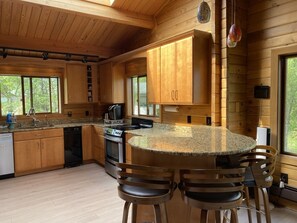 Enjoy cooking in this well-equipped kitchen with a stove, sink, and dishwasher, and dine at the round table with four chairs.