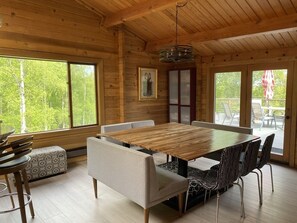 Enjoy meals in this spacious dining area with a large table and comfortable chairs, surrounded by natural views.