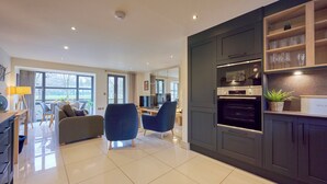 A modern kitchen with dark cabinetry, a Bosch oven, and a built-in wine rack. - Riverside Park 2 (Keswick)