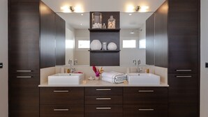 A modern bathroom with two sinks, dark wood cabinetry, and a large mirror. - Petite Grenade - View, sea access, infinity pool and tennis court (Le Vauclin)
