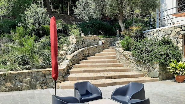 A stone staircase leading up to a building, surrounded by lush greenery and a red umbrella. - HOUSE/LOFT WITH SEA VIEWS, LARGE SWIMMING POOL, VERY QUIET. 2.5 KM FROM THE BEACH (Canet de Mar)
