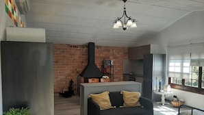 A modern living room with a black sofa, a small table, and a fireplace. - HOUSE/LOFT WITH SEA VIEWS, LARGE SWIMMING POOL, VERY QUIET. 2.5 KM FROM THE BEACH (Canet de Mar)