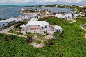 Una propiedad costera con varias casas, un muelle y un edificio central grande con techo blanco y detalles azules.