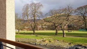 A park with a grassy area, trees, a stone wall, and a river. - Riverside Park 4 (Keswick)