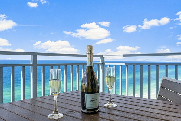 A bottle of Iamarco Prosecco and two glasses on a wooden table with a view of the ocean. - SUMMER DISCOUNT! LUX Beachfront Condo!!Walk to Pier Park-Beach Chairs Included! (Panama City Beach)