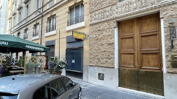 Un bâtiment avec une façade en pierre, une porte double en bois et une enseigne indiquant « FERRAMENTA PRATI - VERNICI - COLORI ».