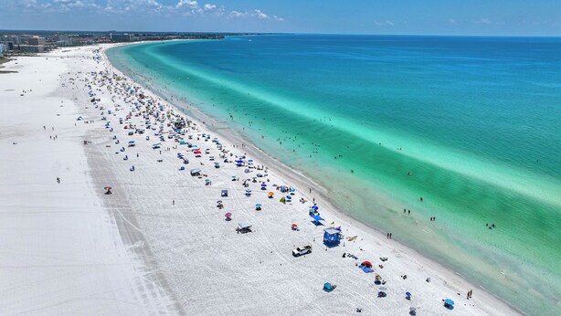 A wide beach with clear turquoise waters and a long stretch of white sand. - Lovely 2 Bedroom/ 2 Bath Across Siesta Key Beach! (Siesta Key)