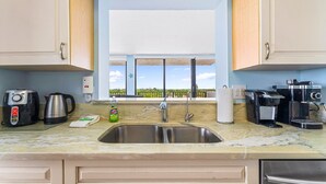 A kitchen with a stainless steel sink, a coffee maker, and a kettle. - Lovely 2 Bedroom/ 2 Bath Across Siesta Key Beach! (Siesta Key)