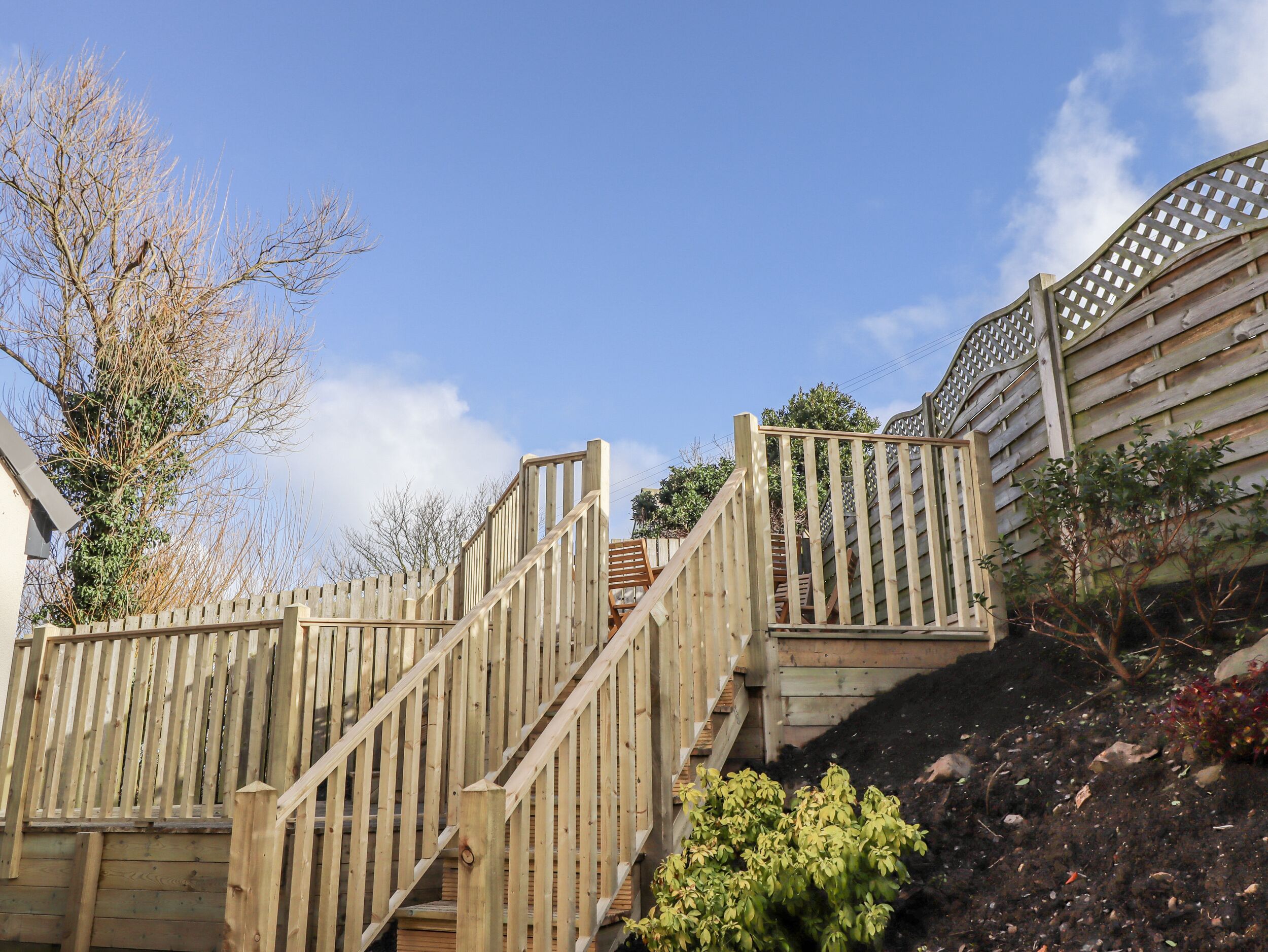 A wooden staircase with a handrail leading up to a building.