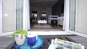 A modern living room with a sofa, a coffee table with magazines, and a potted plant. - Anchors Rest (Y Felinheli)