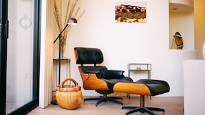 A modern living room with a black leather sofa, a floor lamp, a woven basket, and a framed picture on the wall. - Luxury West Sedona home close to everything (Sedona)